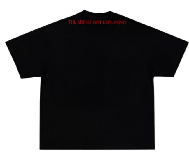 Black oversized t-shirt with red text reading THE ART OF NOT EXPLAINING on the back