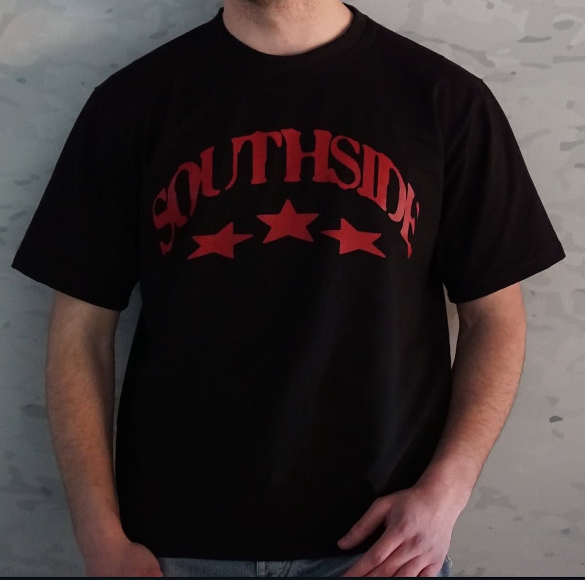 Person wearing black t-shirt with red Southside text and three stars design